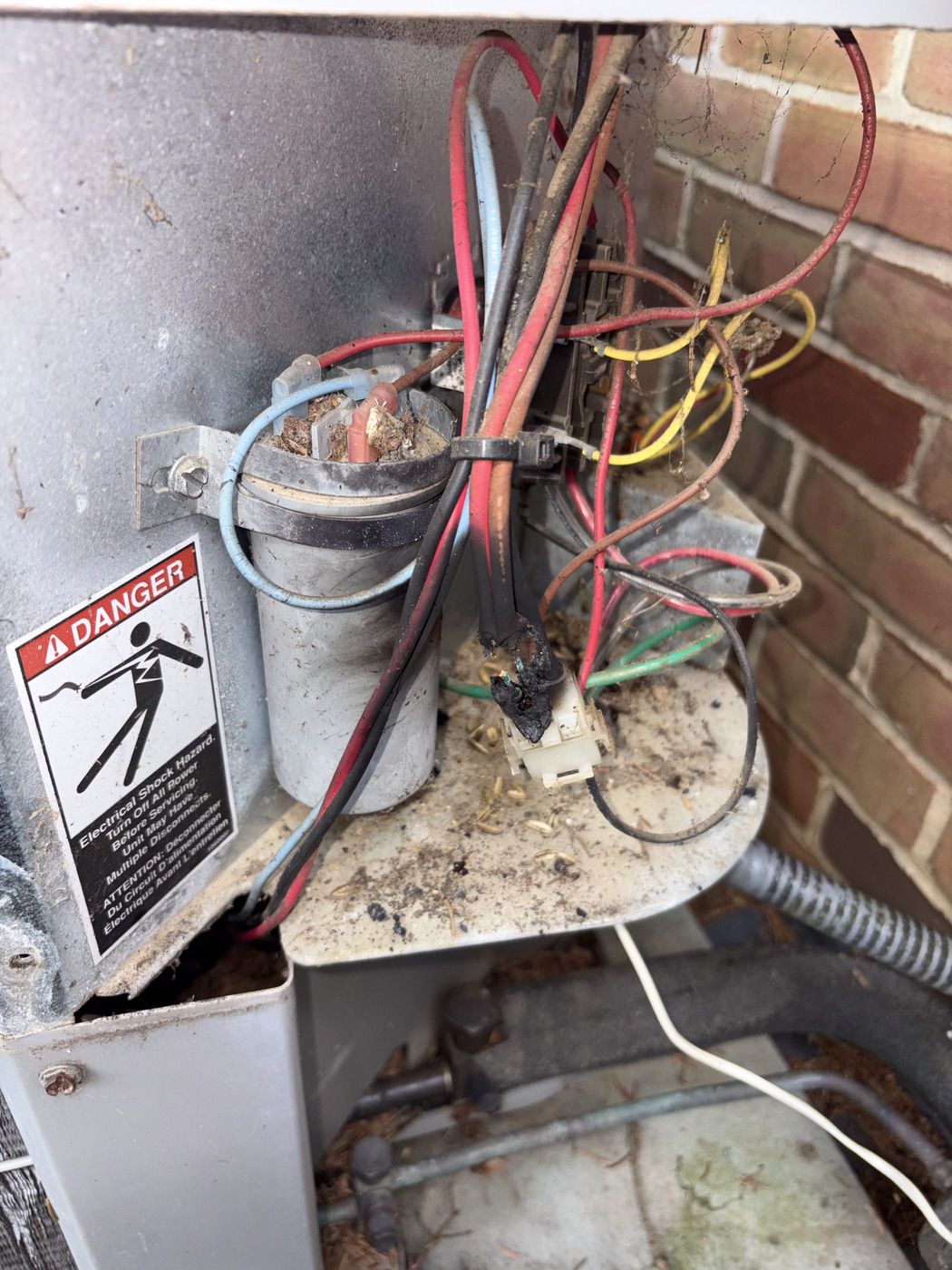 Burned-out contactor and run capacitor found in an opened AC disconnect during a Tom Falk service call.