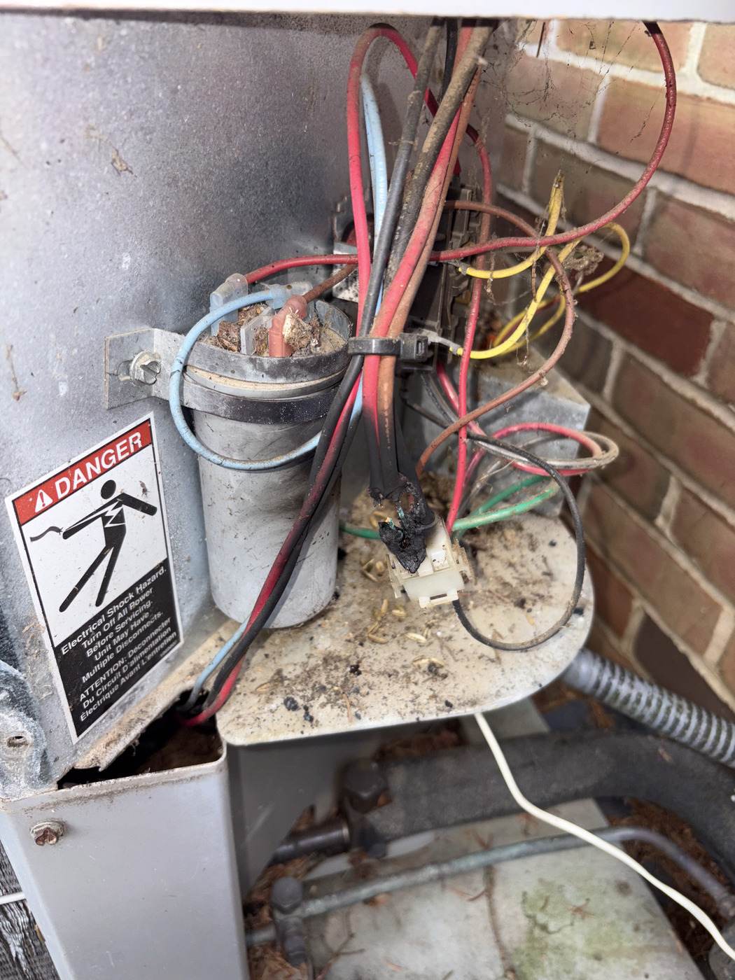 Burned-out contactor and run capacitor found in an opened AC disconnect during a Tom Falk service call.