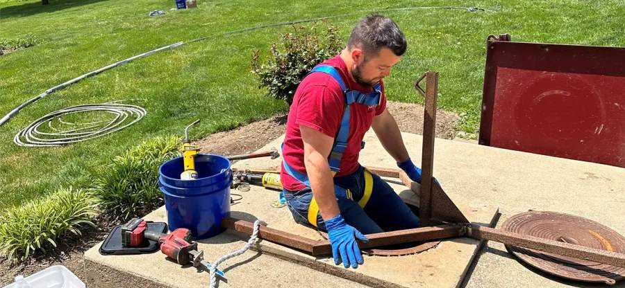 Trevor from Tom Falk lowering himself into a hand-dug well on a Southern End service call.